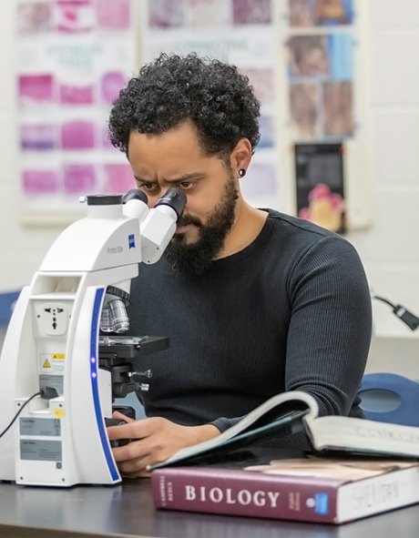 Andre Gomes peers into microscope