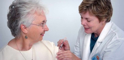 woman getting a shot from a nurse