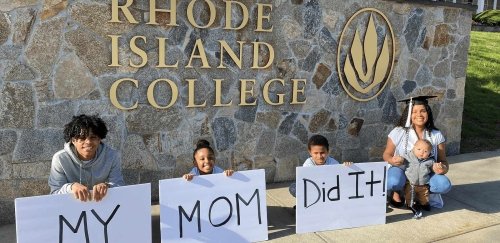 Three kids holding up a "my mom did it!" sign with a women and a baby.