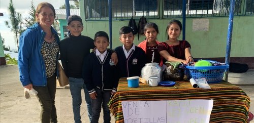 Erin Papa stands beside children selling tortillas