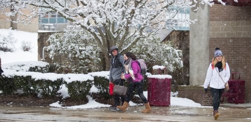 Students walking in falling snow on the quad