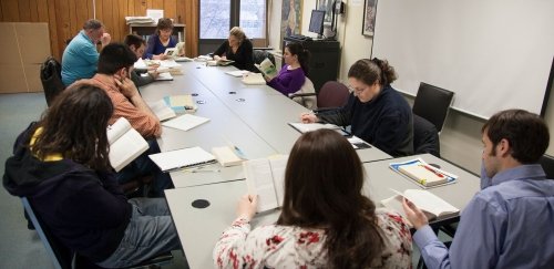 English graduate students reading and working around a large table together