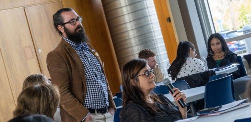 Brandon Hawk with students at tables during Open Books Open Minds