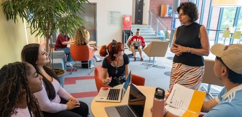 Carol Cummings talking with students in the lobby of Horace Mann