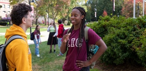 Students talking on campus on a sunny, fall day
