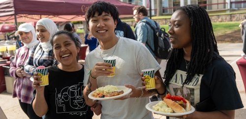 Students enjoying food outside on the quad at the block party