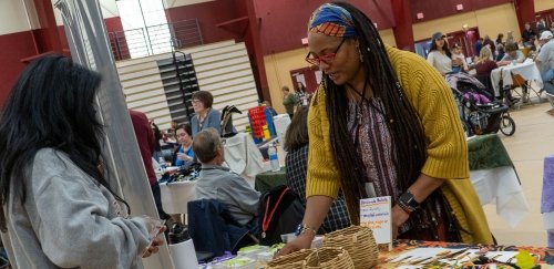 Alum selling crafts at table