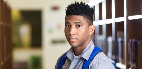 Black male student with backpack on