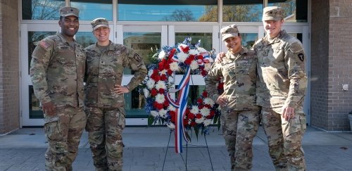 Four student vets with wreath on veterans day