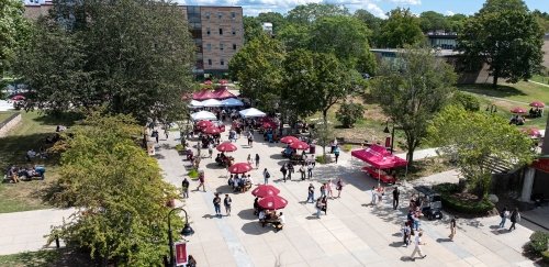Campus quad, with umbrellas up and people crossing