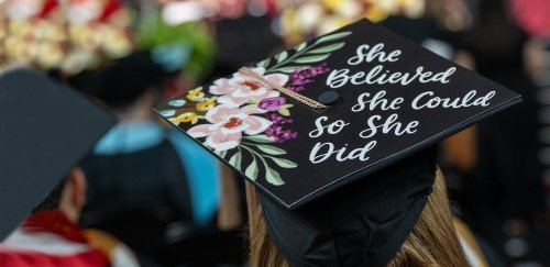 Graduate wearing cap that says "She believed she could so she did"