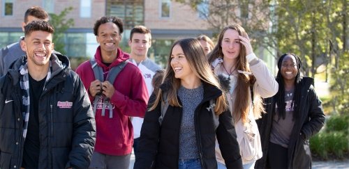 Group of students in RIC gear walking in the sunshine on the quad
