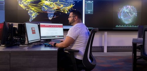 Student working at two computer monitors in the cyber security range