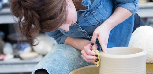 Student working at pottery wheel