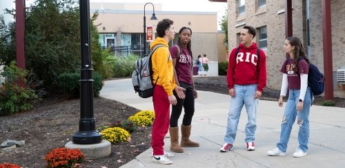 Four students in RIC gear talking near quad