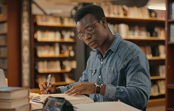 Man working in library, surrounded by books