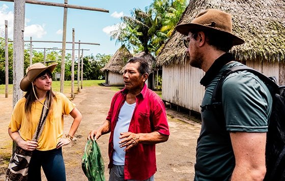 Two anthropologists speaking with citizen of small village