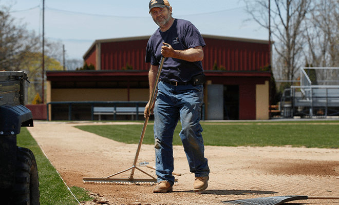 Happy grounds keeper working in the sunshine 