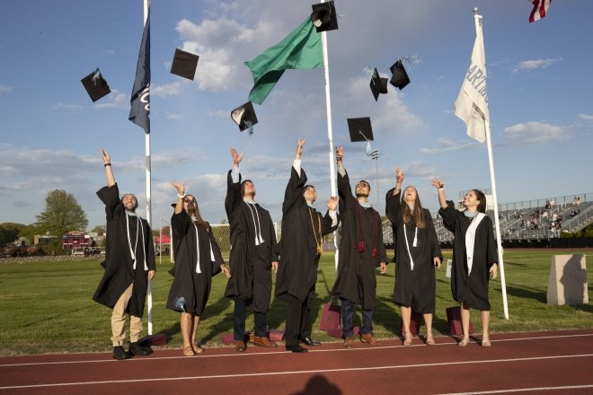 FSHED graduates tossing caps in the air