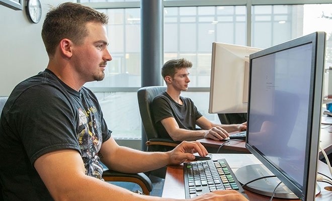 Two students working at computers in Finance Lab, Cybersecurity