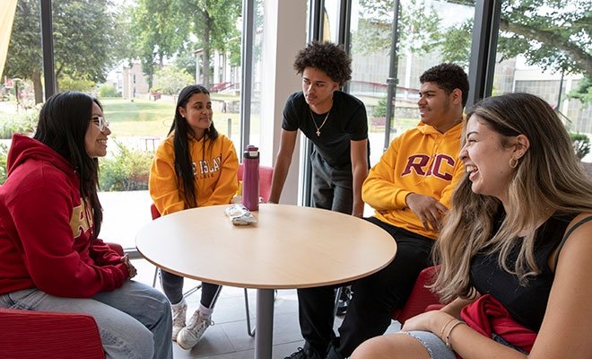 Students talking happily around a table