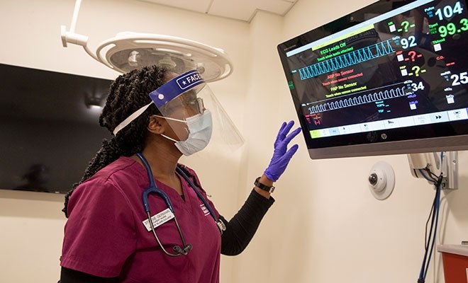 RINEC nursing student looking at monitor