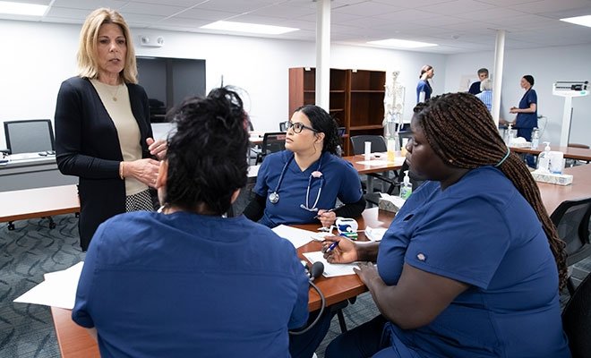 Students in scrubs, being instructed at the Workforce Development Hub