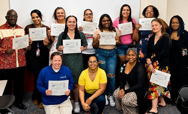 Healthcare workers certificate program graduates holding their certificates
