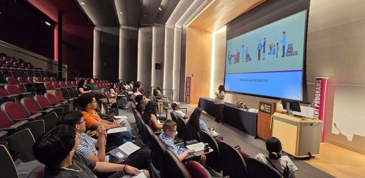 Joise Carzon and Estrellita Moronta, social work professors, speaking in auditorium to highschoolers