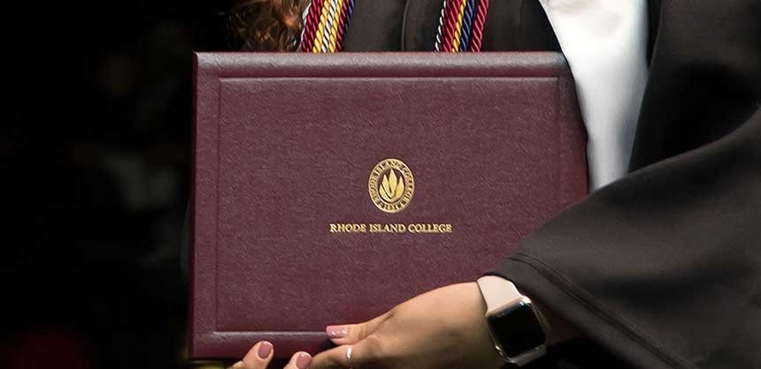 RIC graduate holding diploma case