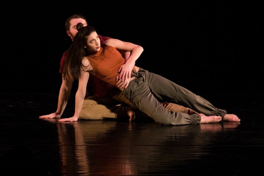 Two dance students in motion together on the stage