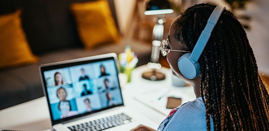 Woman at laptop on zoom call with 9 people