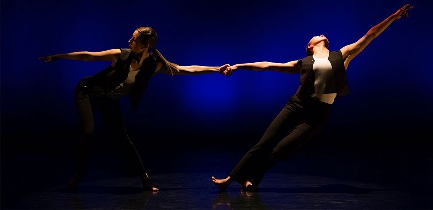 Two dancers dancing together dramatically in spotlight
