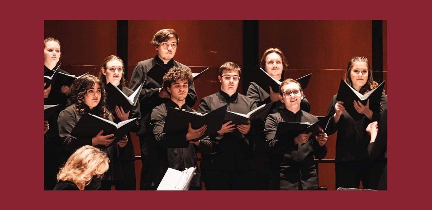 Members of the RIC Chorus in black attire holding songbooks